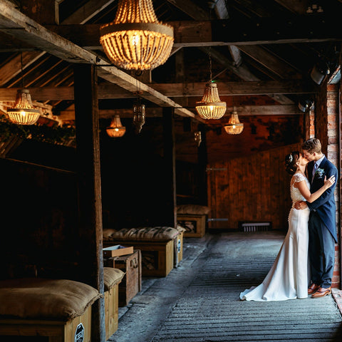 Beaded Pendnat lights hanging in wedding venue above bride and groom.