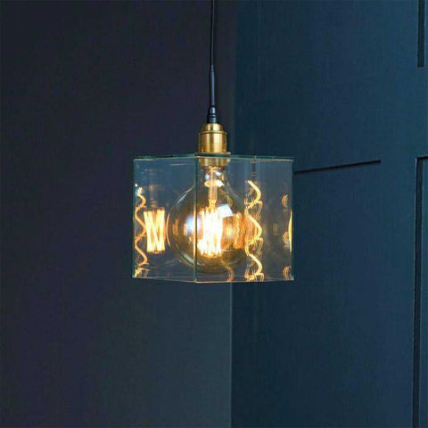 Bramley Bathroom clear glass cube pendant light with exposed bulb hanging in dark room