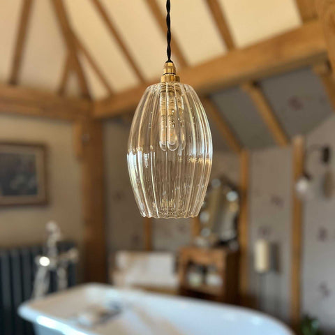 Camber medium ribbed glass shade pendant light hanging in rustic bathroom interior