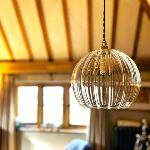 Soho large ribbed glass shade pendant light hanging in warm bathroom setting