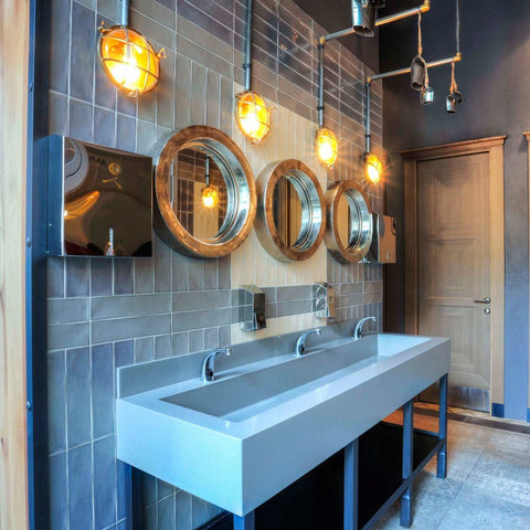 Modern bathroom with Wessex Bulkhead Wall Lights in satin brass above round mirrors and a long white sink