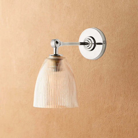 Tiny Qilin Bathroom Wall Light with chrome prismatic glass shade and elbow arm mount on beige wall