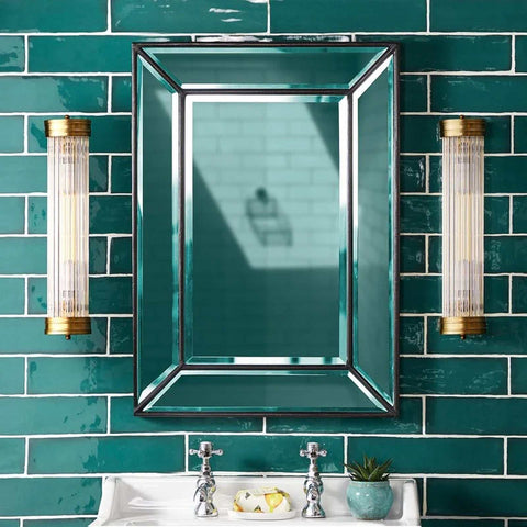 Pooky Long Roddy bathroom wall lights with glass rods and brass finish on green tiled wall by mirror and sink