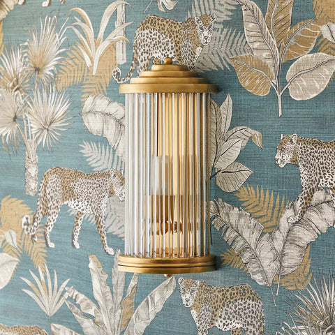 Baby Roddy Bathroom Wall Light with clear glass rods and polished brass semi-circular fitting on tropical leopard wallpaper