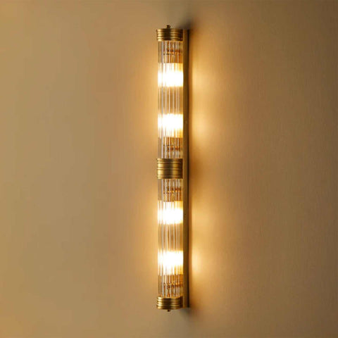 Pooky Rodtastic Bathroom Wall Light in brass finish with four illuminated bulbs and vertical ribbed glass design