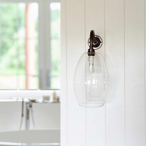 Camber medium clear glass shade bathroom wall light with bronze swan neck fitting mounted on white wooden panel wall