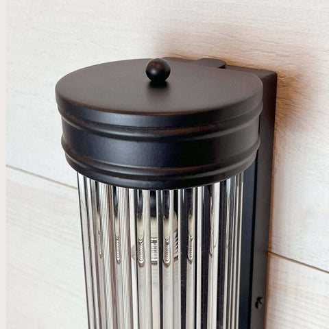Modern black reeded bathroom wall light with sleek glass rods and elegant, functional design