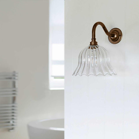 Bodium small ribbed glass shade bathroom wall light with bronze fitting mounted on white wall