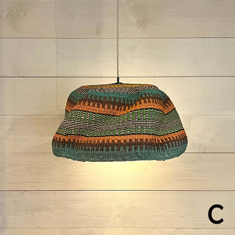 Large woven colourful basket pendant light made from natural elephant grass with vibrant striped design hanging from ceiling