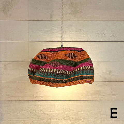 Woven colourful basket pendant light made from natural elephant grass with vibrant stripes hanging from ceiling