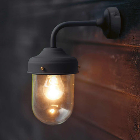St Ives Outdoor Wall Light in carbon finish mounted on wooden exterior wall with glowing bulb