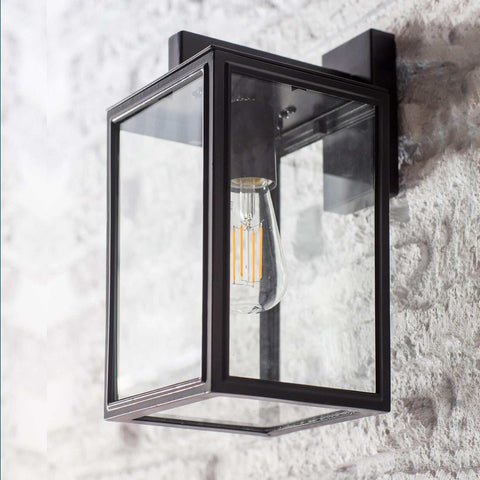 Outdoor carriage light with off-black finish and glass panels.