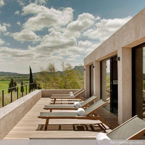 Modern outdoor terrace with Bourne Outdoor Mast Lights mounted on a beige stucco wall overlooking scenic landscape