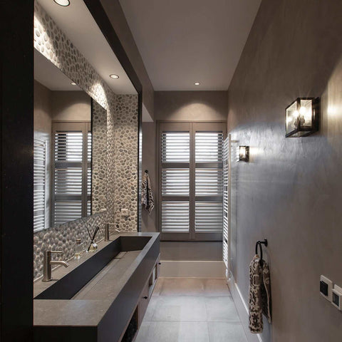 Chiswick Outdoor Double Lamp wall light mounted in modern bathroom with neutral tones and textured wall tiles.