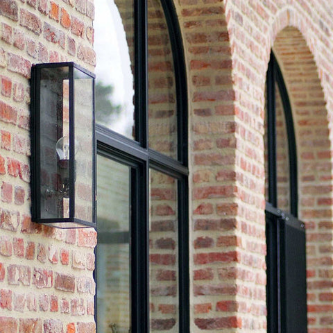 Chiswick Outdoor Wall Light large black metal frame with clear glass mounted on brick wall beside arched window