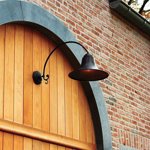 Kew Outdoor Wall Light extra large black metal lantern mounted on brick wall above wooden arched door