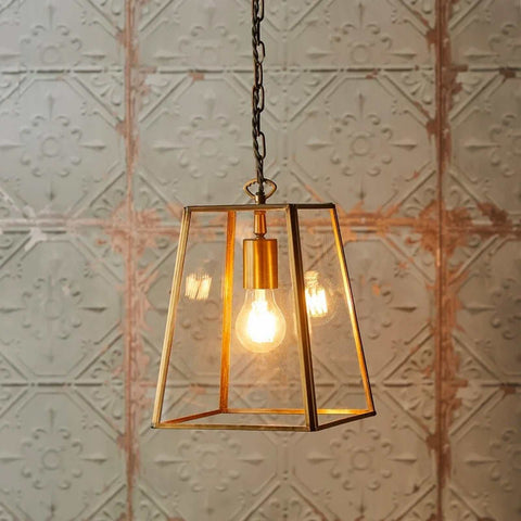 Medium Luxor Lantern Pendant light with clear glass panels and antiqued brass frame illuminating warm light