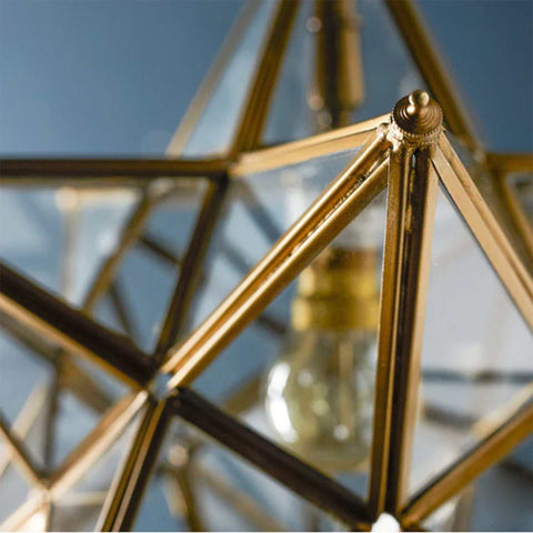 Close-up of Pooky Stella Star Pendant Light with faceted clear glass and brass detailing