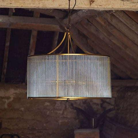 Artemis Chandelier pendant light with brass frame and clear glass rods in rustic ceiling setting