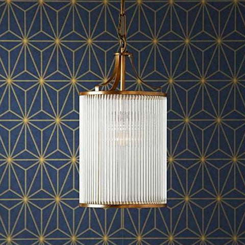 Pooky Valli Pendant Light with brass finish and glass rod lantern design hanging against geometric patterned wall