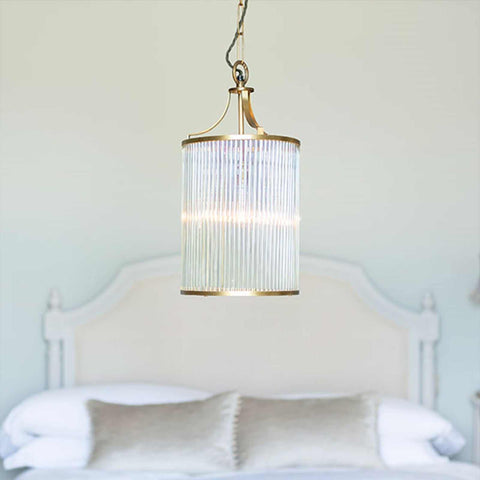 Pooky Valli Pendant Light with brass finish and glass rod lantern design hanging above bed in bedroom