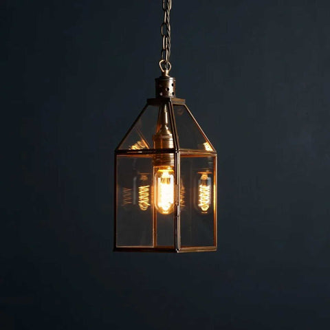 Pooky Carrington Lantern pendant light in antique brass with vintage glass lantern and glowing filament bulb