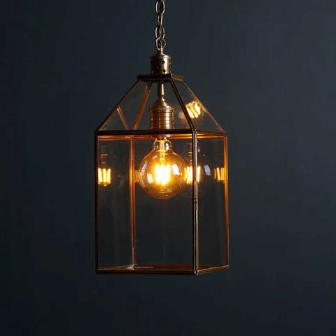 Pooky Carrington Lantern large vintage brass pendant light with glass panels and warm glowing filament bulb