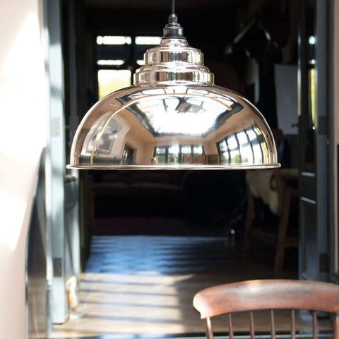 Brampton Nickel Pendant Light with polished reflective solid brass finish hanging above dining table in modern interior