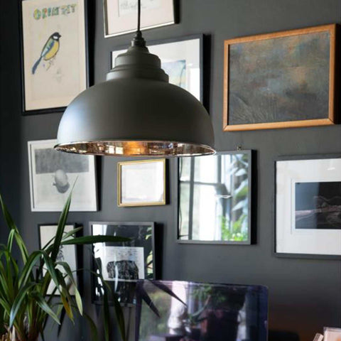 Brampton Grey Pendant Light with domed shape and polished nickel interior hanging above a desk in a modern living space with framed artwork and plants.