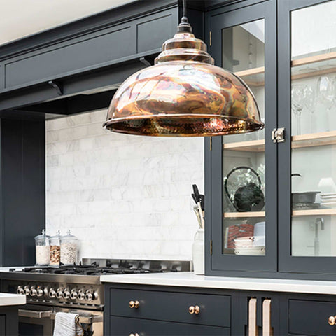 Brampton burnished pendant light with hand-burnished brass finish and hammered interior hanging in modern kitchen