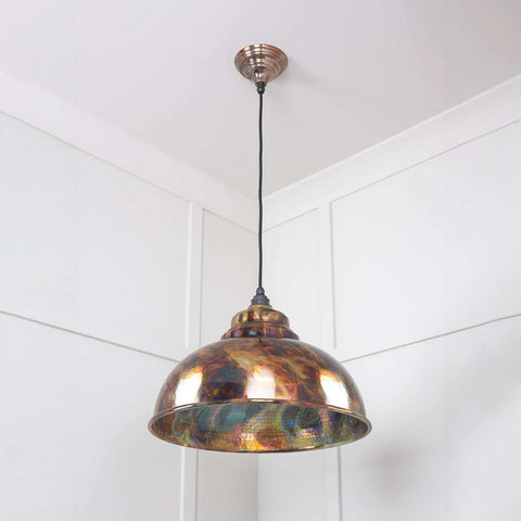 Brampton burnished pendant light with hand-burnished multi-color metal finish and hammered interior, hanging from ceiling in a white room