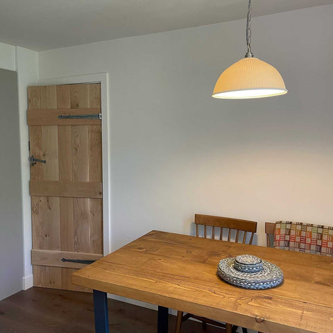 Denton Large Ribbed Ceramic Shade pendant light hanging above wooden dining table in modern room