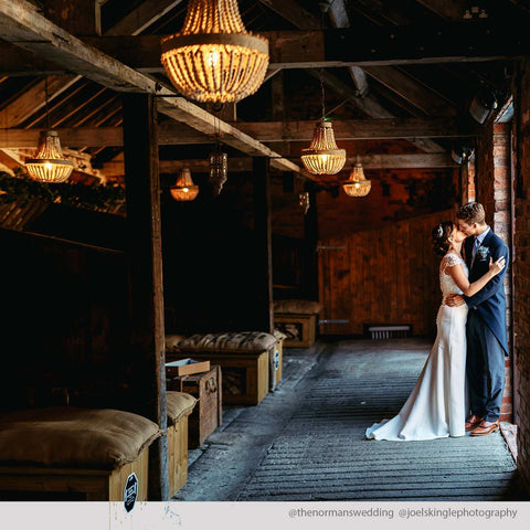 Small Luna Wooden Ceiling Pendant Light with handcrafted wooden beads illuminating a rustic wedding venue with a bride and groom.