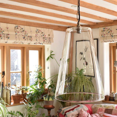 Newbury Extra Large clear tapered glass pendant light hanging in cozy room with plants and wooden beams