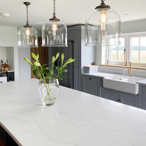 Hythe Large Clear Glass Shade pendant lights hanging above kitchen island with modern white countertop and grey cabinetry