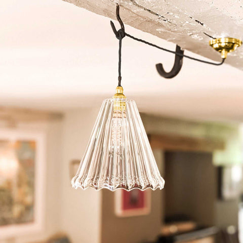 Rye Ribbed Pendant Light with fluted clear glass shade hanging from black cord and brass fixture in modern interior