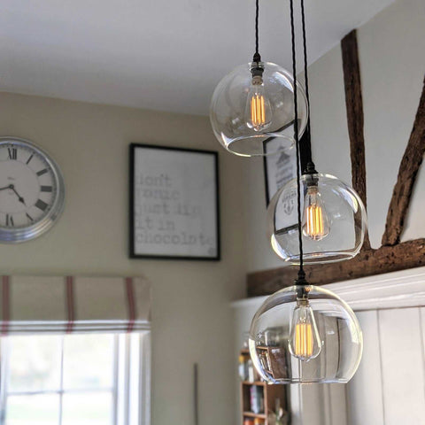 Soho large clear glass shade cluster pendant light with hand-blown globes and adjustable black flex cords in a modern dining room setting