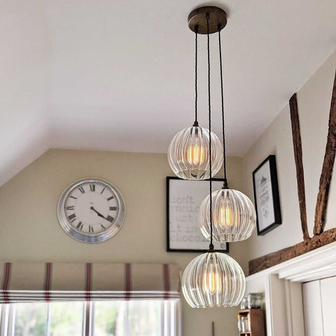 Soho large ribbed glass shade cluster pendant light with three hand-blown glass globes hanging in a cozy living space