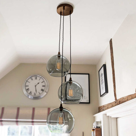 Soho large smoked glass shade cluster pendant light with three adjustable smoked glass globes hanging from a rustic ceiling rose in a modern room setting