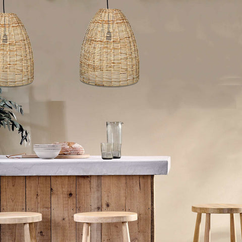 Nkuku Noko wicker conical pendant light hanging above a wooden kitchen island with stools, creating a warm, rustic atmosphere