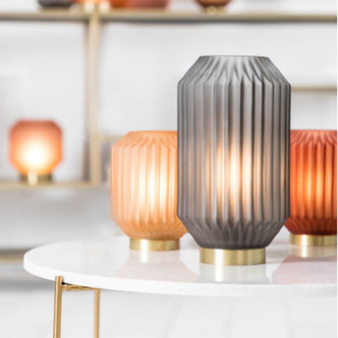 Orton Grey Glass cordless table lamp with ribbed design and warm ambient light on white table