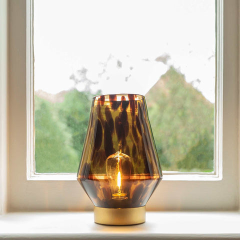 Osita Glass Cordless Table Lamp with tapered glass body and warm ambient light on window sill