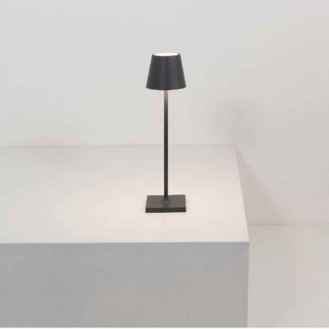 Zafferano Poldina Micro rechargeable black table lamp with minimalist design on white surface