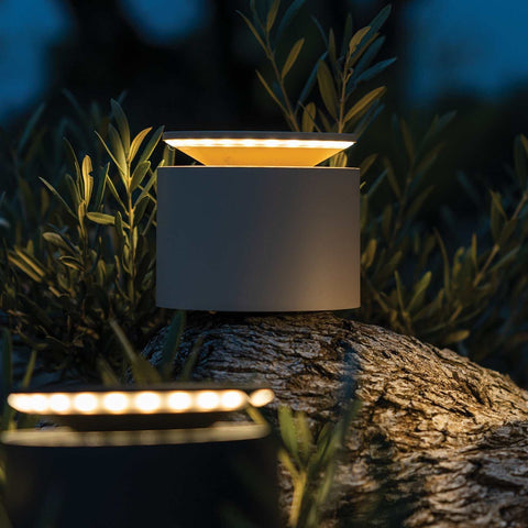 Zafferano Push-up rechargeable table lamp emitting warm light on outdoor wooden surface at night