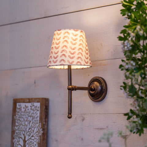 Finberry fabric shade Lupin wall light with patterned shade and bronze finish mounted on wooden wall