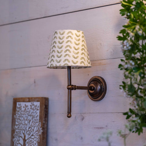 Finberry fabric shade Lupin wall light with patterned shade and bronze finish mounted on wooden wall