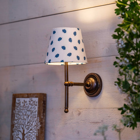 Finberry Fabric Shade Lupin wall light with floral fabric shade and brass finish mounted on wooden wall