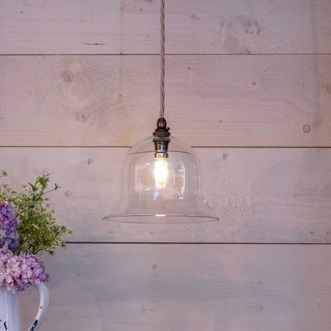 Bodium Medium Clear bell-shaped glass pendant light hanging with exposed bulb and rustic wood background