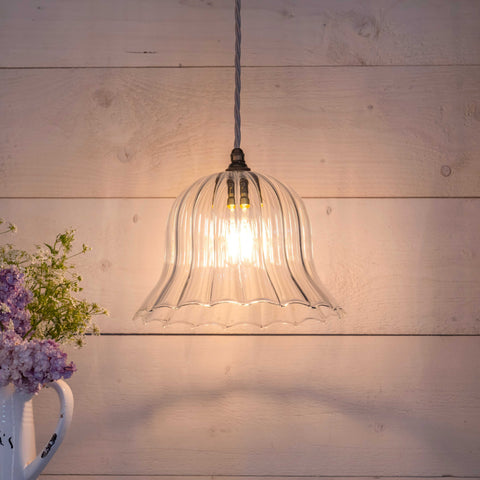 Bodium large ribbed glass shade pendant light with warm glow hanging over wooden wall background