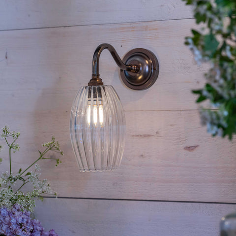 Camber small ribbed glass shade wall light with fluted hand-blown glass and bronze finish mounted on wooden wall
